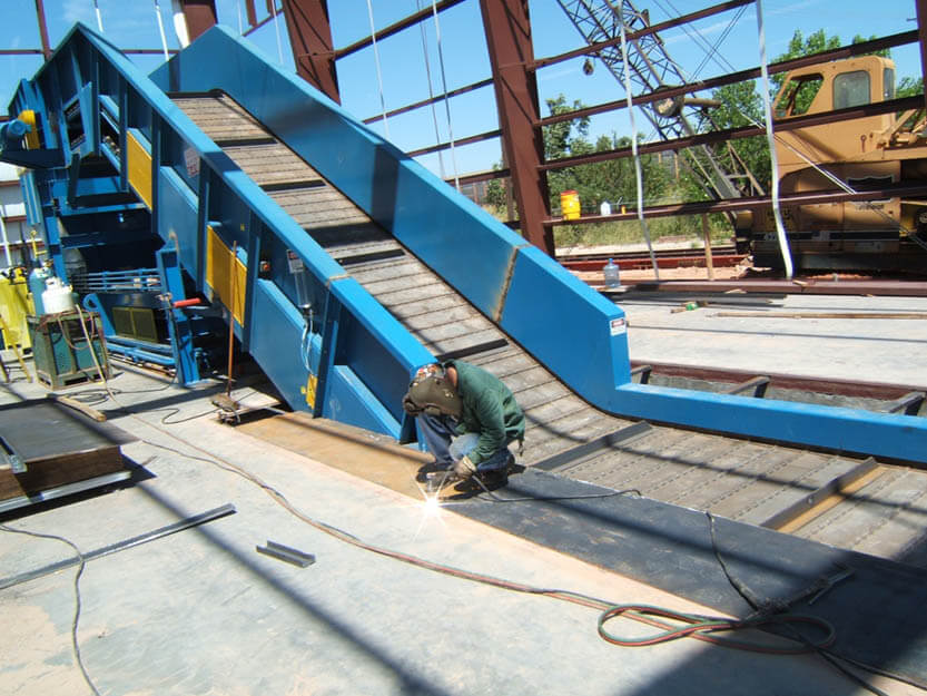 HSC technician welding pit cover on in-ground conveyor installation